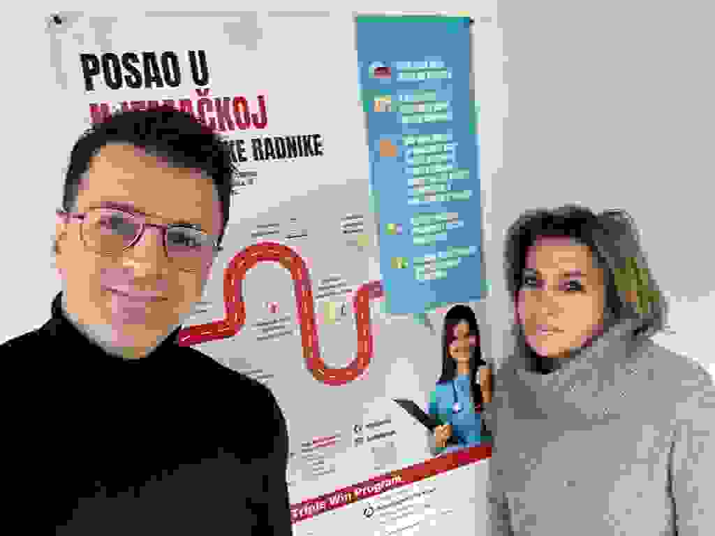 Two people pose in front of a poster with information on job opportunities in Germany, including training courses and certificates.